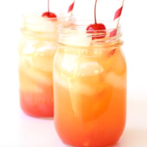 Shirley Temples in mason jars with cherries on top.