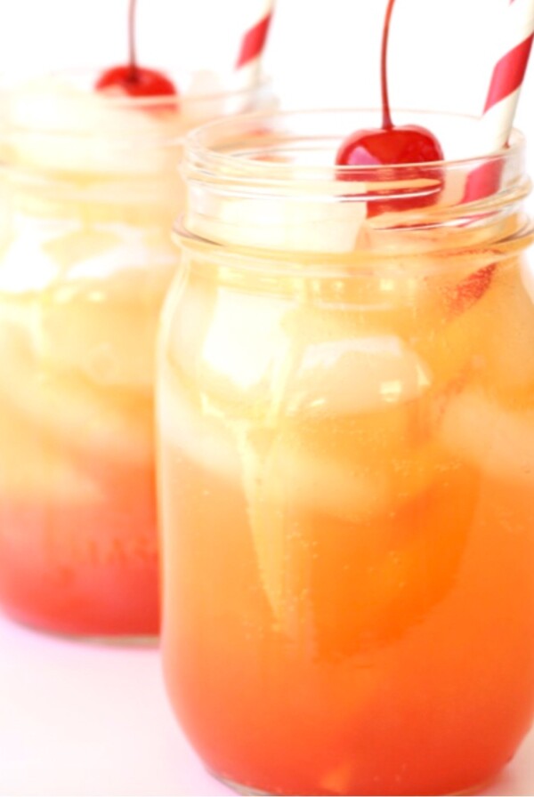 Shirley Temples in mason jars with cherries on top.