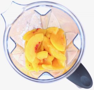 Blender with peach punch ingredients.