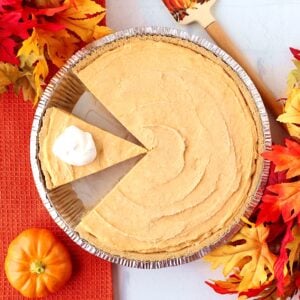 No Bake Pumpkin Pie in graham cracker crust with slice of pie cut.