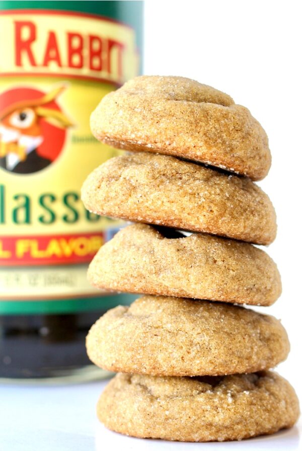 Stack of soft and chewy ginger snaps cookies with molasses bottle in background.