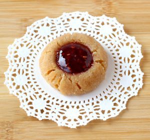Jelly-filled peanut butter cookie on a doily.