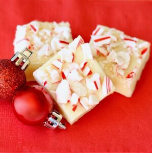 Three pieces of white chocolate Christmas fudge.