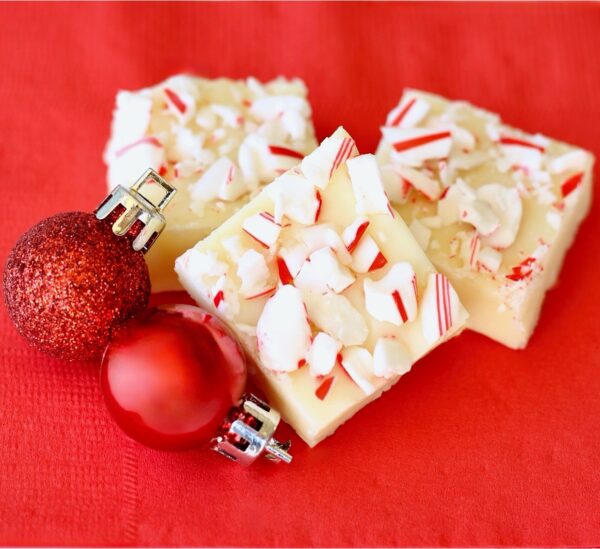 Three pieces of while chocolate Christmas fudge on napkin.