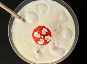 Eggnog Punch in a bowl with a small Santa umbrella.