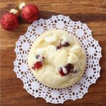 Cranberry cookie with white chocolate chips on a doily.