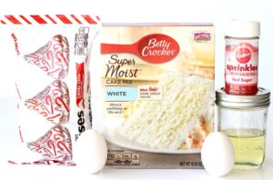 Candy Cane Kiss Cookie ingredients including eggs, white cake mix, and red sugar sprinkles.