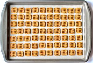 Square pretzels on a lined baking sheet.