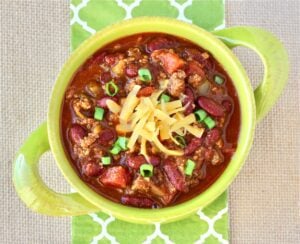 Bowl of chili topped with shredded cheese.