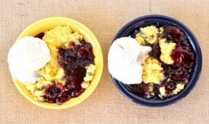 Blueberry Lemon Dump Cake in two bowls with ice cream.