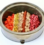 Beef chili ingredients unmixed in crock pot.