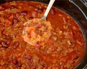 Spoon scooping chili from an Instant Pot.