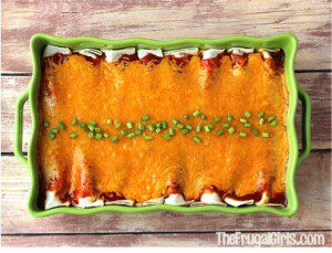 Beef enchiladas topped with cheese in a green baking dish.