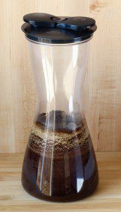 Coffee grounds in a thin pitcher with a lid.