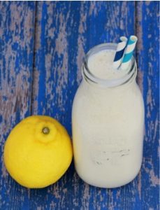 Frosted lemonade in a tall jar with a lemon.