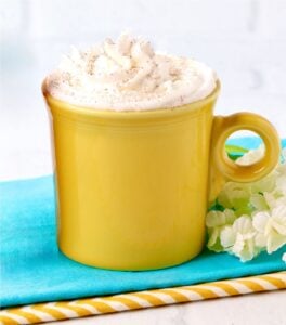 Caramel apple cider in mug with napkins beneath.