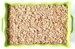 Crumble topping over pumpkin mixture in a baking dish.
