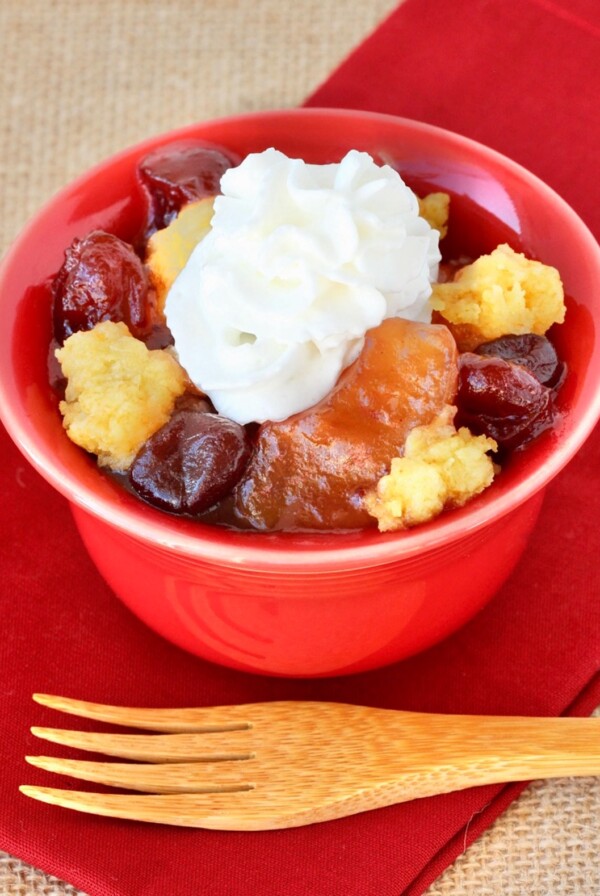 Cranberry Apple Dump Cake topped with whipped cream.