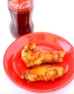 Cooked chicken wings on plate with barbecue sauce.