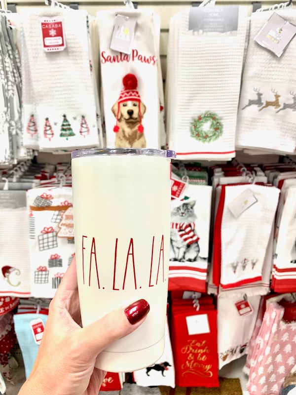 Fa la la travel mug in front of holiday towels.
