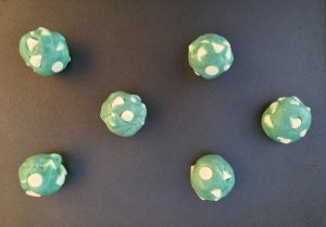 Balls of cookie dough on a baking sheet.