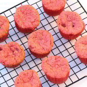 Strawberry angel food cake cupcakes sitting on a wire rack.