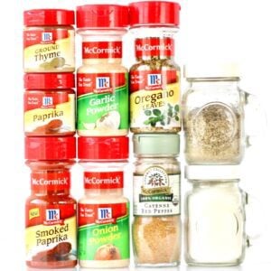 Spices on a white surface, including paprika, oregano, and cayenne pepper.