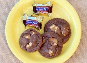 Snickers and Snickers cookies on a yellow plate.