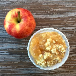 Apple with a bowl of caramel apple dump cake.