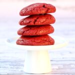 Stack of four red velvet cake mix cookies on cookie stand.
