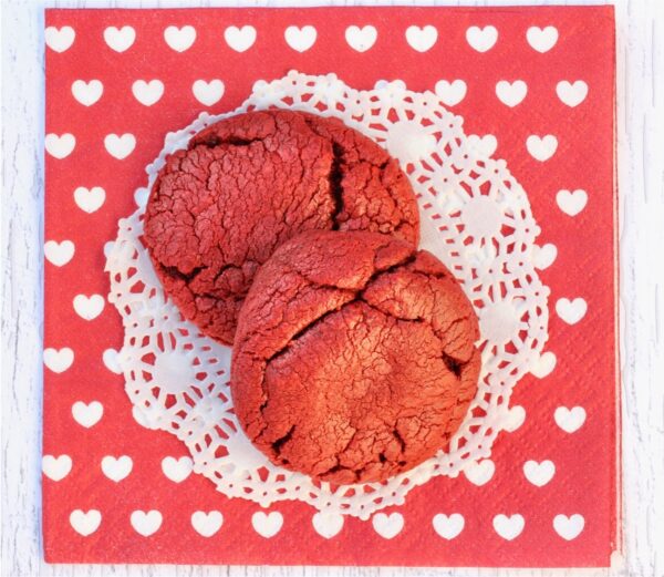 Two red velvet cookies on napkin.
