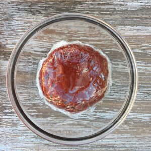 Plastic-wrapped cookie dough in a bowl.