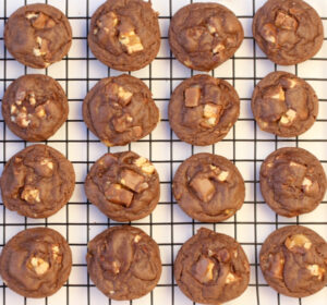 Snickers cookies cooling on a wire rack.