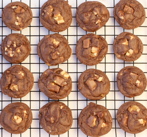 Snickers cookies cooling on a wire rack.