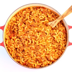 American goulash in Dutch oven with wooden spoon.