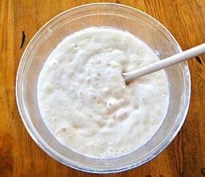 Spoon stirring pineapple angel food cake batter.