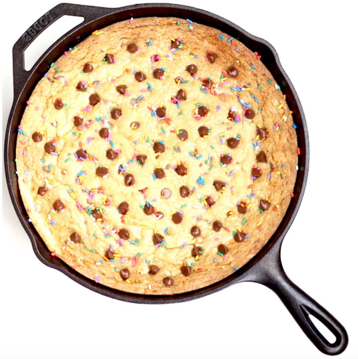Baked chocolate chip skillet cookie with sprinkles in cast iron skillet.