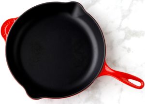 Empty skillet with a red handle.
