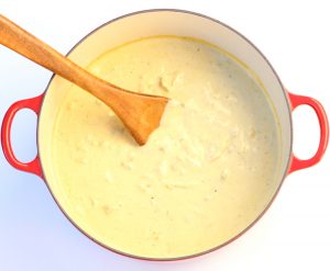 Wooden spoon in a pot of chicken enchilada soup.