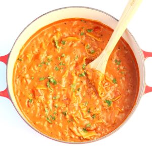 Lasagna soup in Dutch Oven with a wooden spoon.