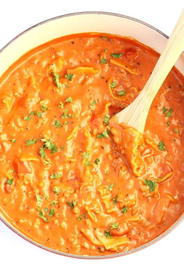 Lasagna soup in Dutch Oven with a wooden spoon.