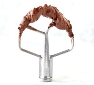 Chocolate frosting on a mixer attachment.