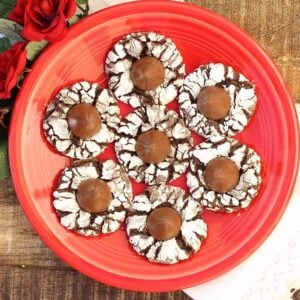 Chocolate kiss cookies on plate with flowers to the side.