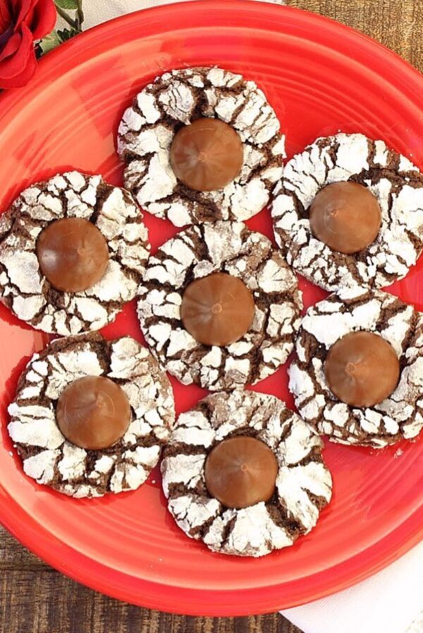 Chocolate kiss cookies on plate with flowers to the side.