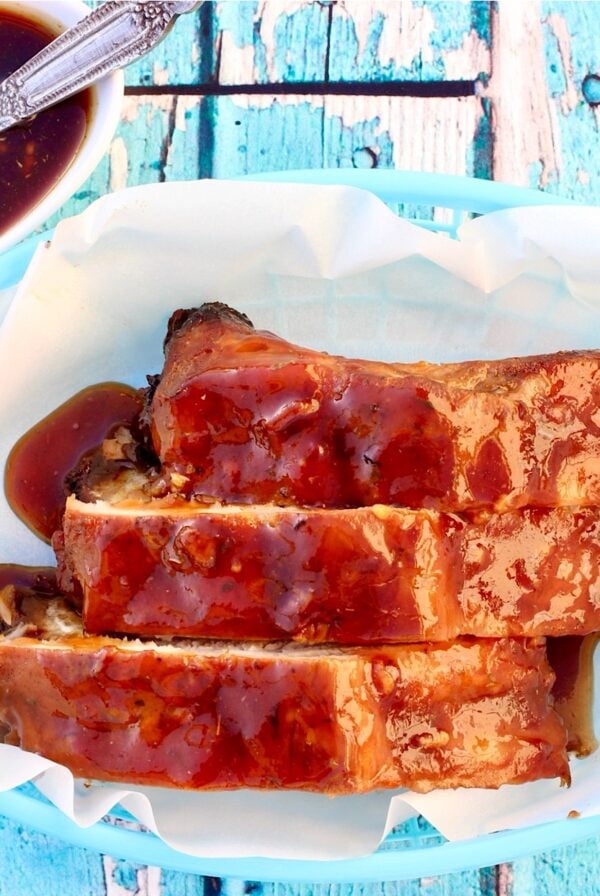 Three pork ribs with honey garlic sauce in basket.