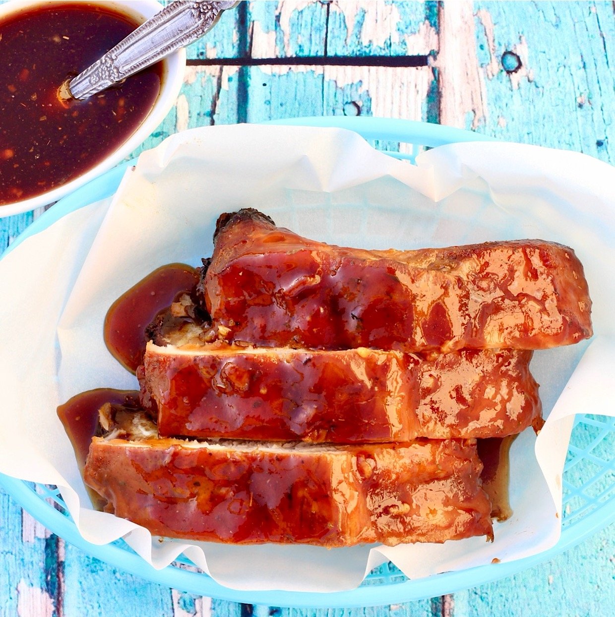 Three pork ribs with honey garlic sauce in basket.