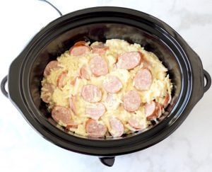 Sliced kielbasa and hash browns in a Crockpot.