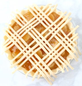 Caramel apple pie with lattice crust on top in process.