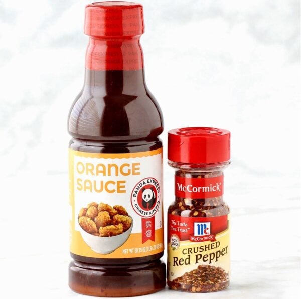 Containers of crushed red pepper and orange sauce.