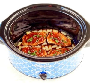 Pork chops in a slow cooker with teriyaki sauce and pineapples.